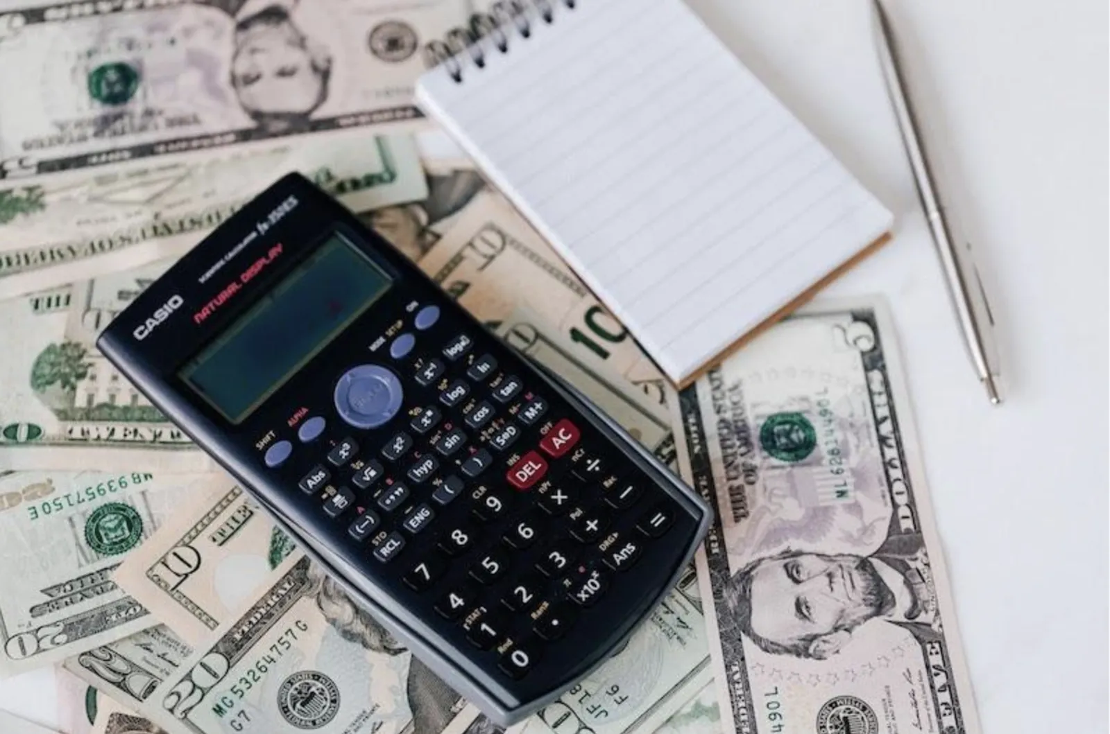 Calculadora, bloco de notas e caneta